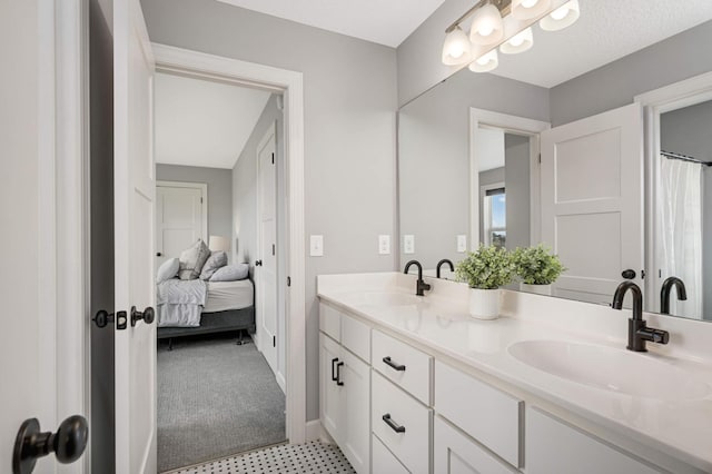 full bath featuring double vanity, a sink, and ensuite bathroom