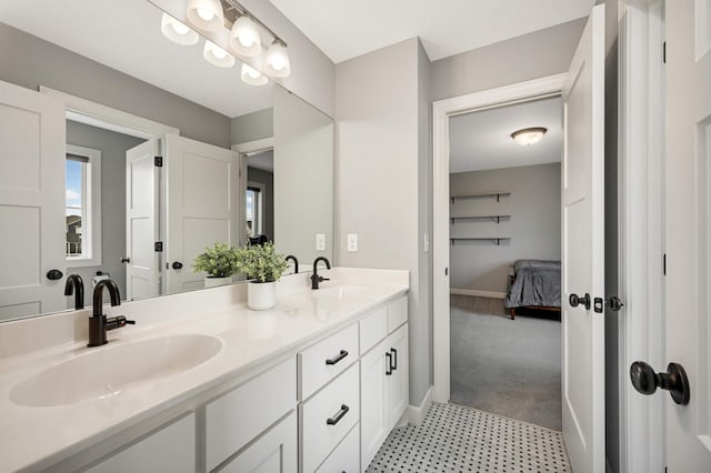 full bathroom featuring a sink, baseboards, and double vanity