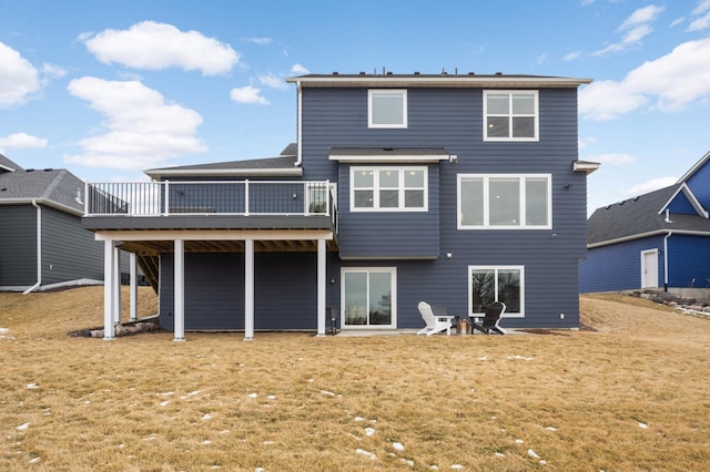 rear view of house with a deck and a lawn