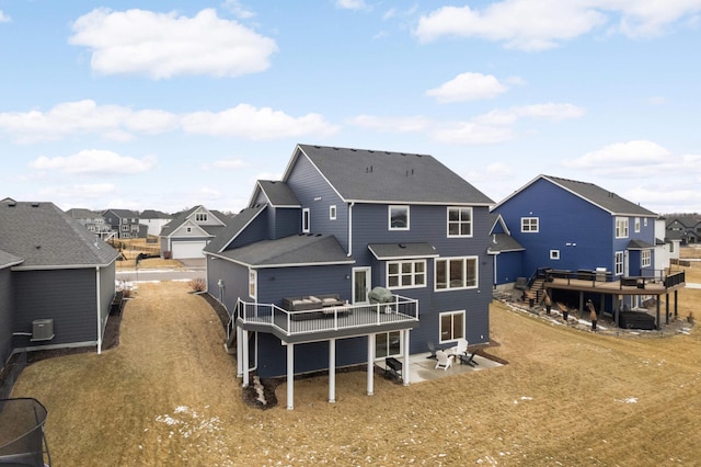 rear view of house with central air condition unit, a residential view, a deck, and a patio