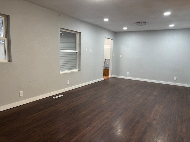 unfurnished room with dark wood-style flooring and baseboards