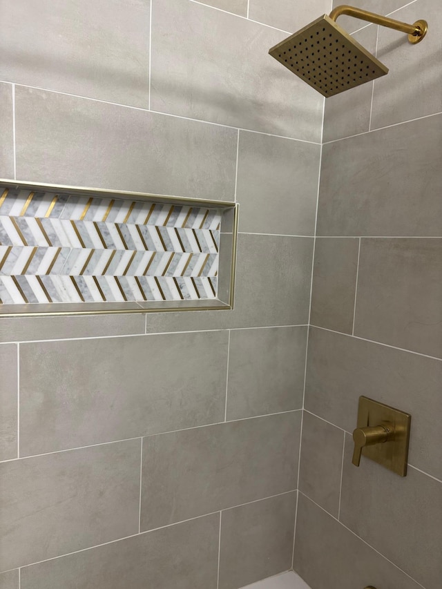 interior details featuring tiled shower