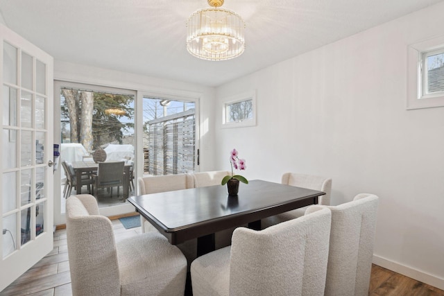 dining room with an inviting chandelier, a wealth of natural light, and wood-type flooring