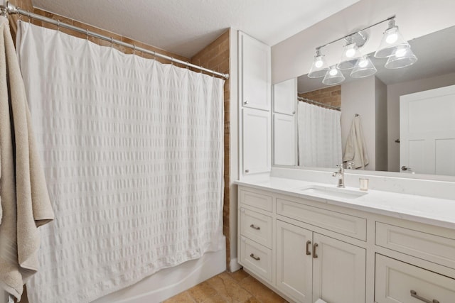 bathroom with shower / bath combination with curtain, vanity, and a textured ceiling