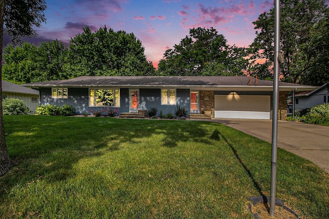 ranch-style home with a yard and a garage