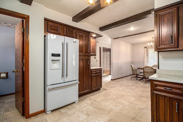 kitchen featuring an inviting chandelier, beam ceiling, white refrigerator with ice dispenser, and dark brown cabinets