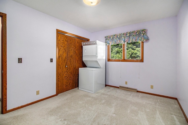 washroom featuring light carpet, a baseboard heating unit, and stacked washer and clothes dryer