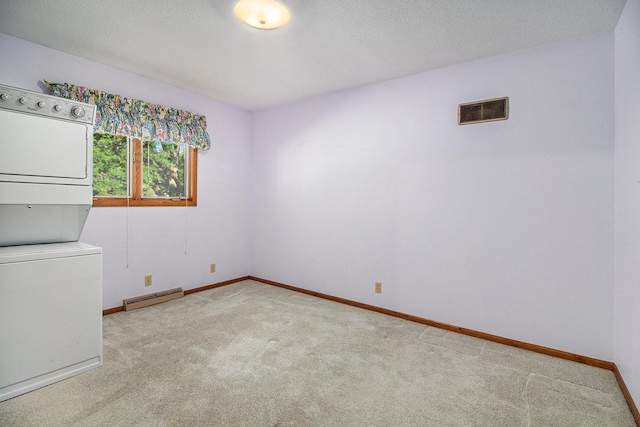 clothes washing area featuring a baseboard radiator, light colored carpet, a textured ceiling, and stacked washing maching and dryer