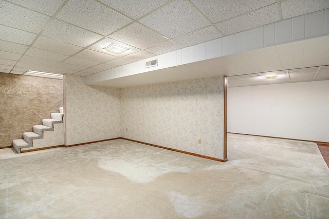 basement featuring a paneled ceiling and carpet floors