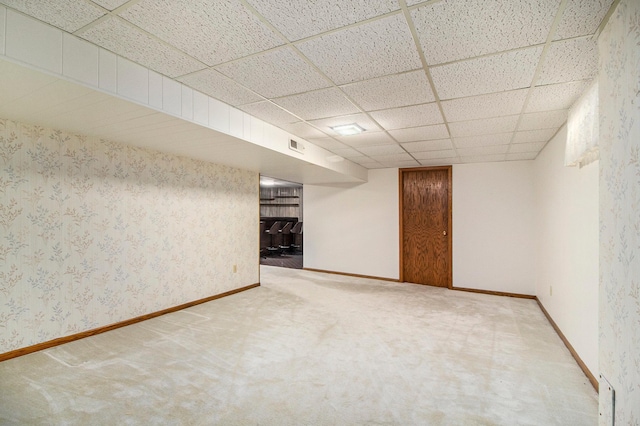 basement featuring carpet and a paneled ceiling