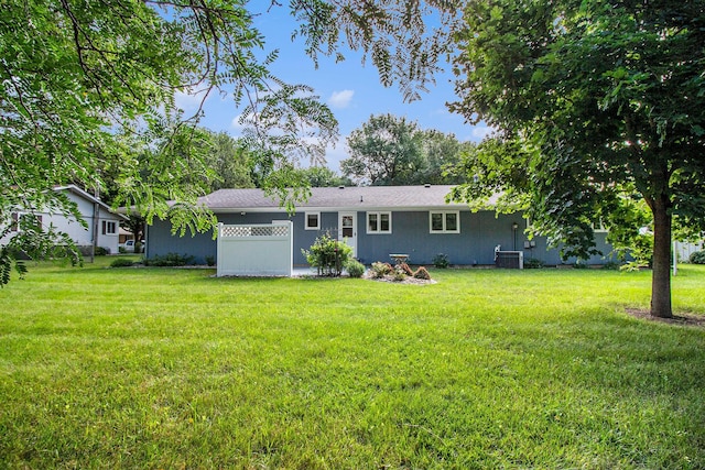 back of property featuring central AC unit and a yard