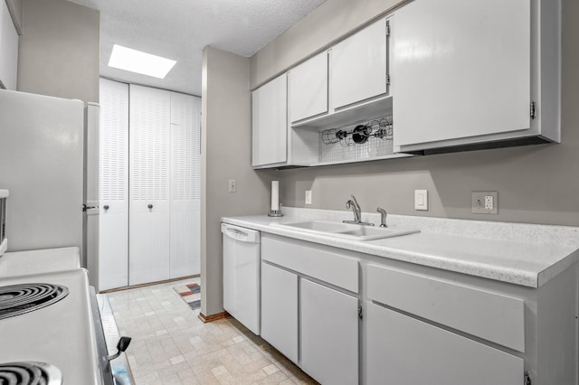 kitchen with white appliances, sink, a textured ceiling, and white cabinets