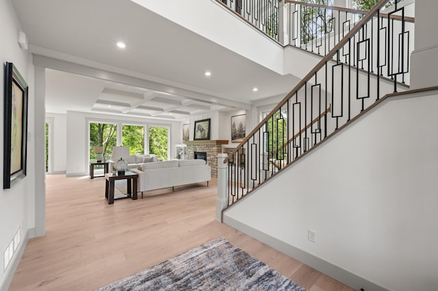 stairs with hardwood / wood-style flooring, coffered ceiling, and beam ceiling