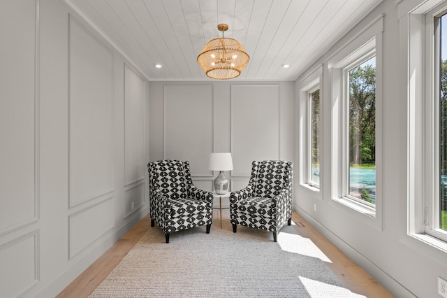 sitting room featuring an inviting chandelier, wood ceiling, and light hardwood / wood-style flooring