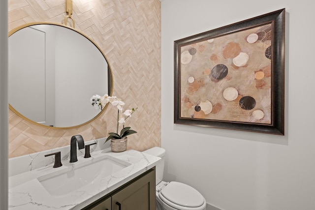 bathroom with vanity, decorative backsplash, and toilet