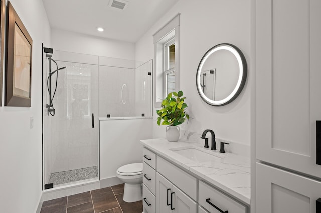 bathroom featuring vanity, an enclosed shower, and toilet