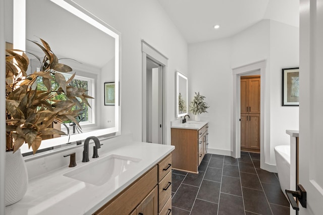 bathroom with tile patterned floors, vanity, and a bathing tub