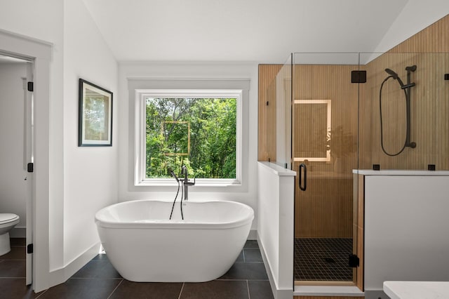 bathroom featuring tile patterned flooring, vaulted ceiling, shower with separate bathtub, and toilet