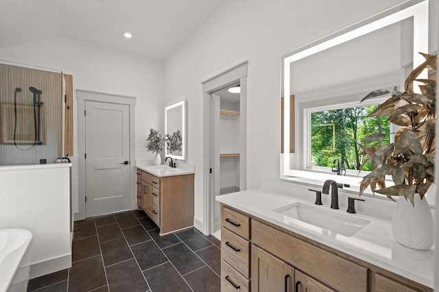 bathroom with tile patterned floors, vanity, and vaulted ceiling