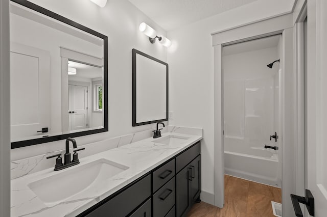 bathroom featuring vanity, shower / tub combination, and a textured ceiling