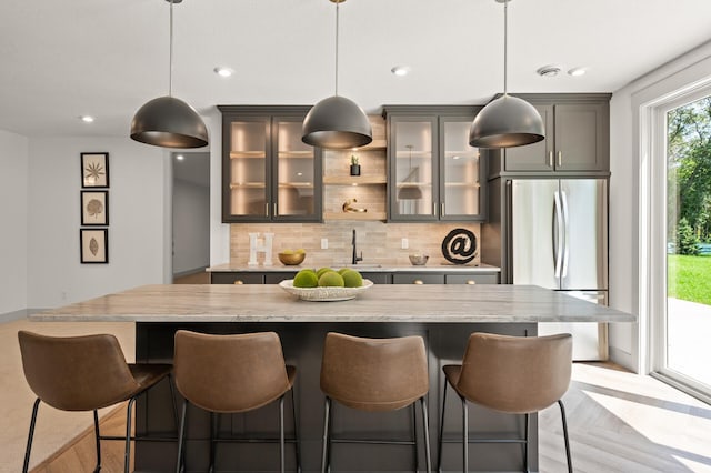 kitchen featuring pendant lighting, stainless steel fridge, and a kitchen breakfast bar