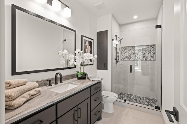 bathroom featuring tile patterned floors, vanity, toilet, and a shower with door