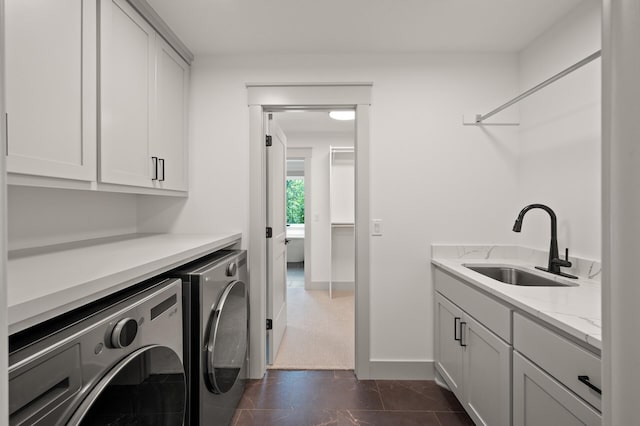 laundry area featuring cabinets, washing machine and clothes dryer, and sink