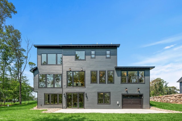 rear view of house featuring a garage, a yard, and a patio area