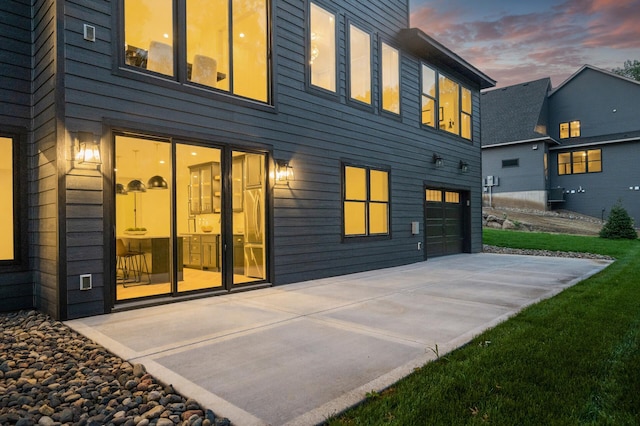 back house at dusk with a garage