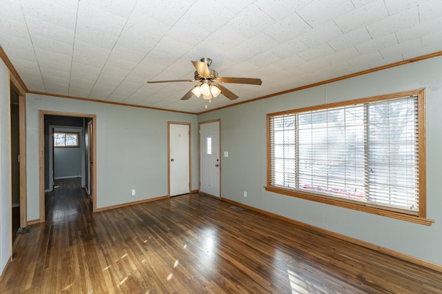 unfurnished living room with ornamental molding, plenty of natural light, and dark wood-type flooring