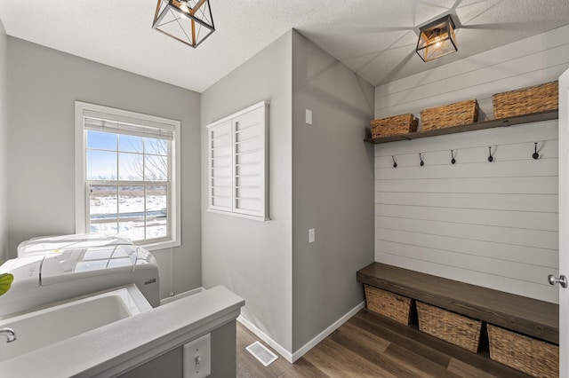 mudroom featuring baseboards, visible vents, dark wood finished floors, a textured ceiling, and a sink