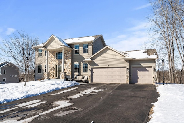 view of front of house with a garage, stone siding, and driveway