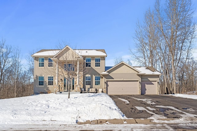 view of front of home with an attached garage, stone siding, and driveway