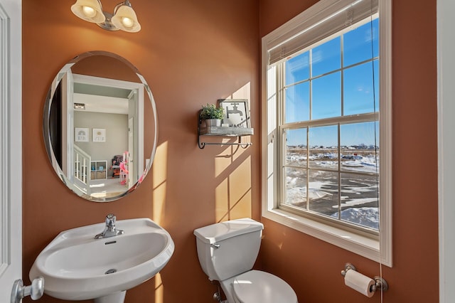 bathroom featuring a chandelier, a sink, and toilet