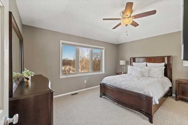 bedroom with visible vents, baseboards, vaulted ceiling, a textured ceiling, and carpet floors