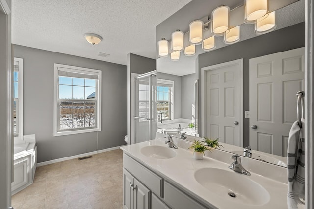 bathroom featuring visible vents, a sink, baseboards, and a bath