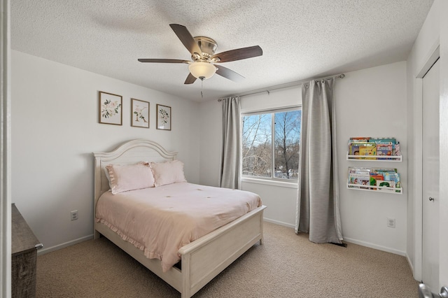 bedroom featuring light carpet, baseboards, and a textured ceiling