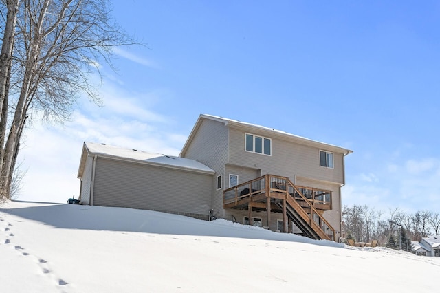 snow covered property featuring stairs and a wooden deck