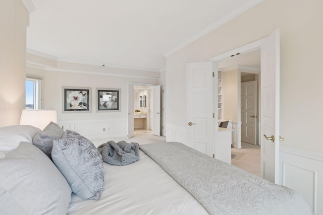 bedroom with crown molding, light colored carpet, and ensuite bathroom