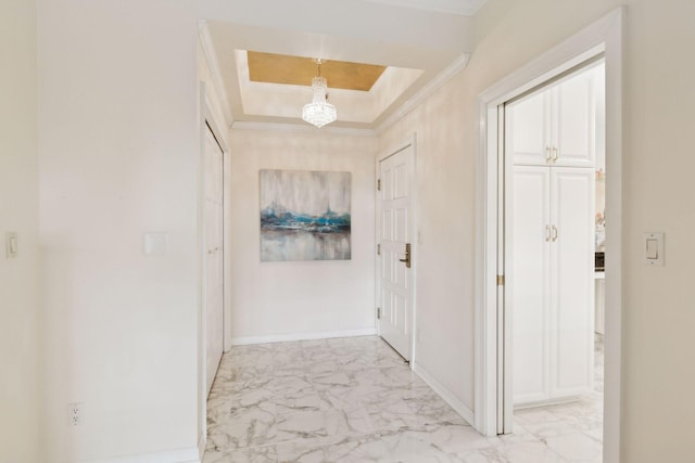 corridor featuring crown molding and a raised ceiling