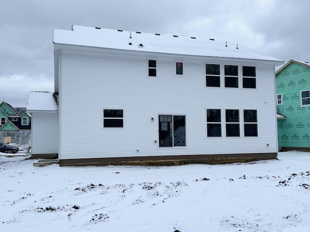 view of snow covered rear of property