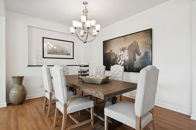 dining area with hardwood / wood-style flooring and a notable chandelier