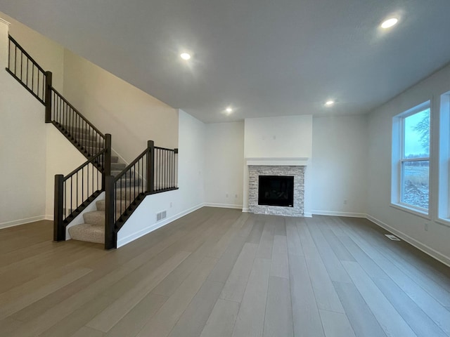 unfurnished living room with hardwood / wood-style flooring and a fireplace