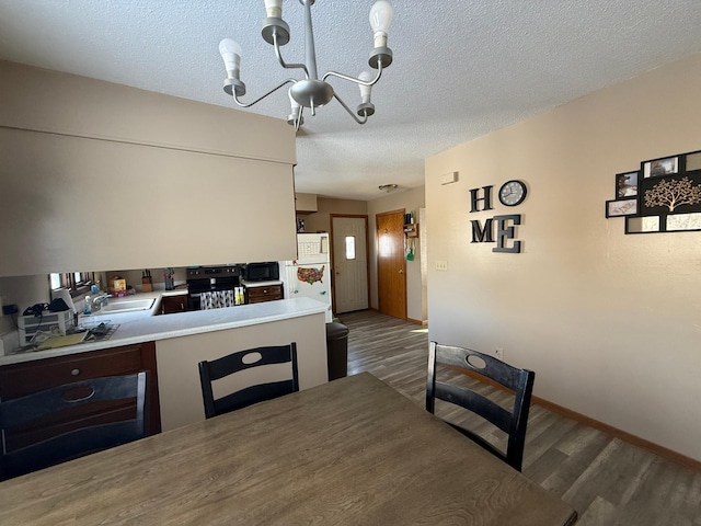 dining space featuring dark hardwood / wood-style floors, sink, a textured ceiling, and an inviting chandelier