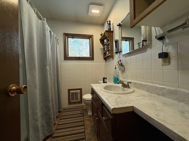 bathroom with tile walls, tile patterned flooring, vanity, a textured ceiling, and toilet