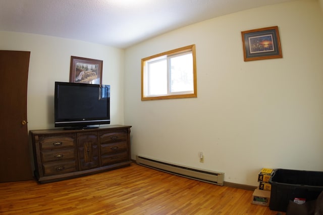 bedroom featuring a baseboard radiator and light hardwood / wood-style floors