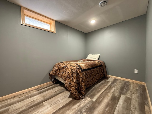 bedroom with dark hardwood / wood-style flooring and a textured ceiling