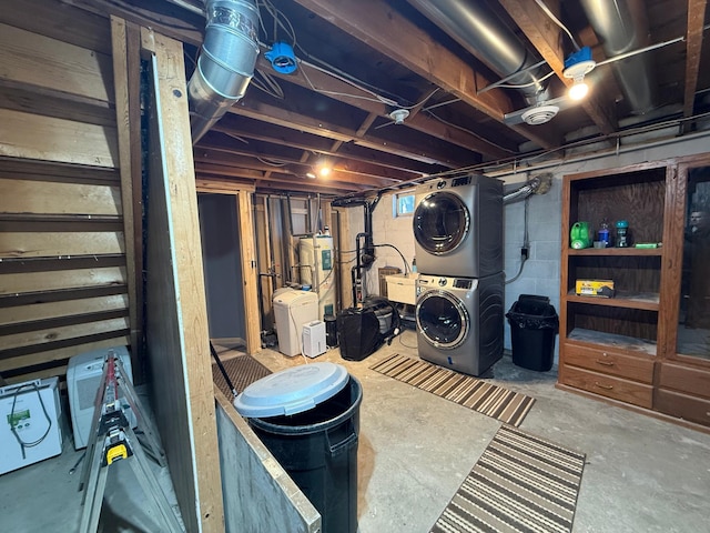 basement featuring electric water heater and stacked washer / drying machine