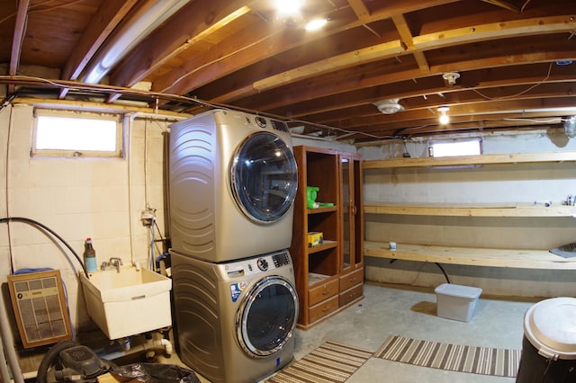 washroom featuring a healthy amount of sunlight, stacked washer / drying machine, and sink