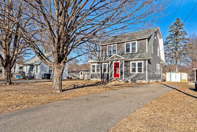 view of front of house featuring a sunroom and a storage unit